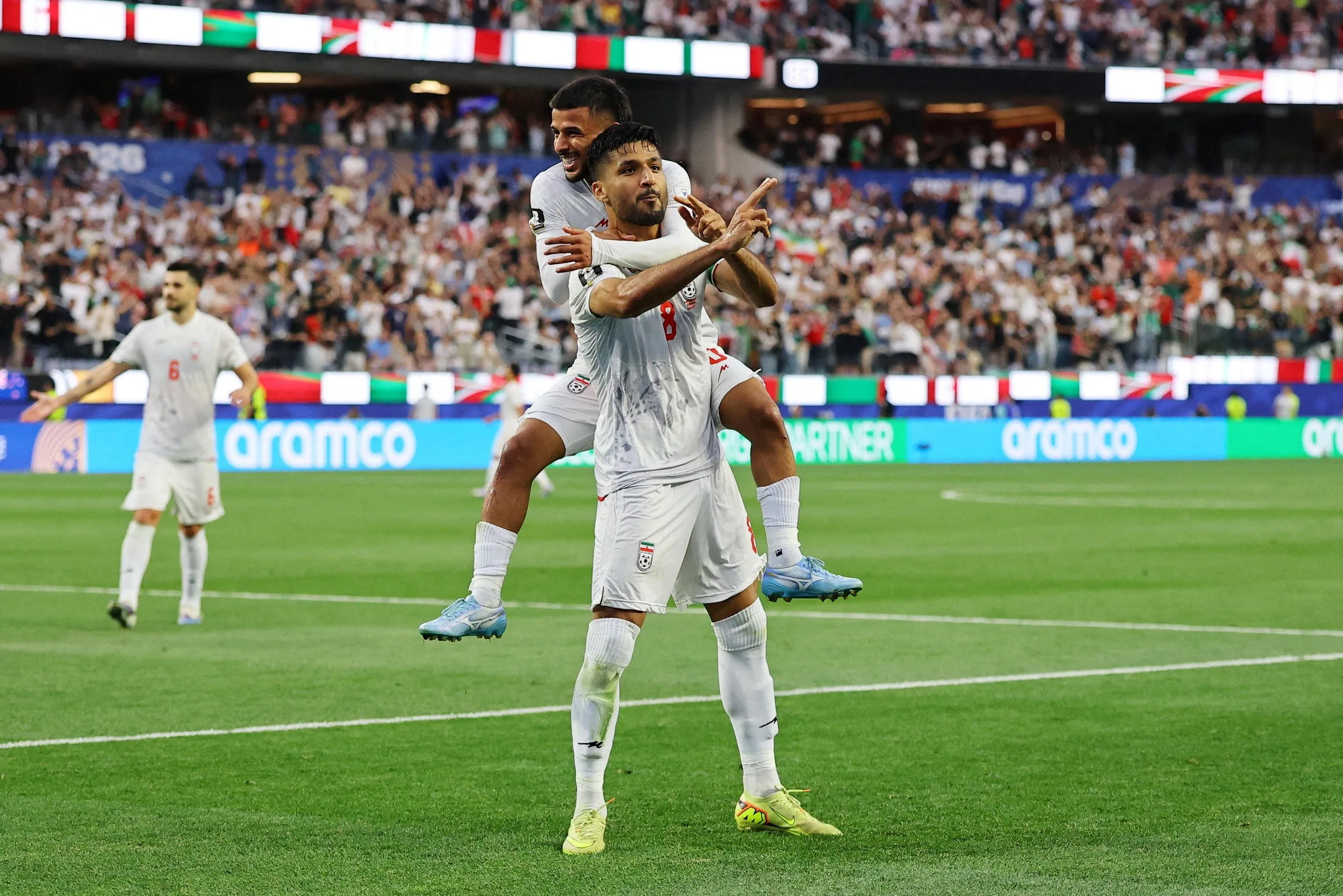 Iran’s Mohammad Mohebbi celebrates scoring their second goal with Mehdi Ghayedi.