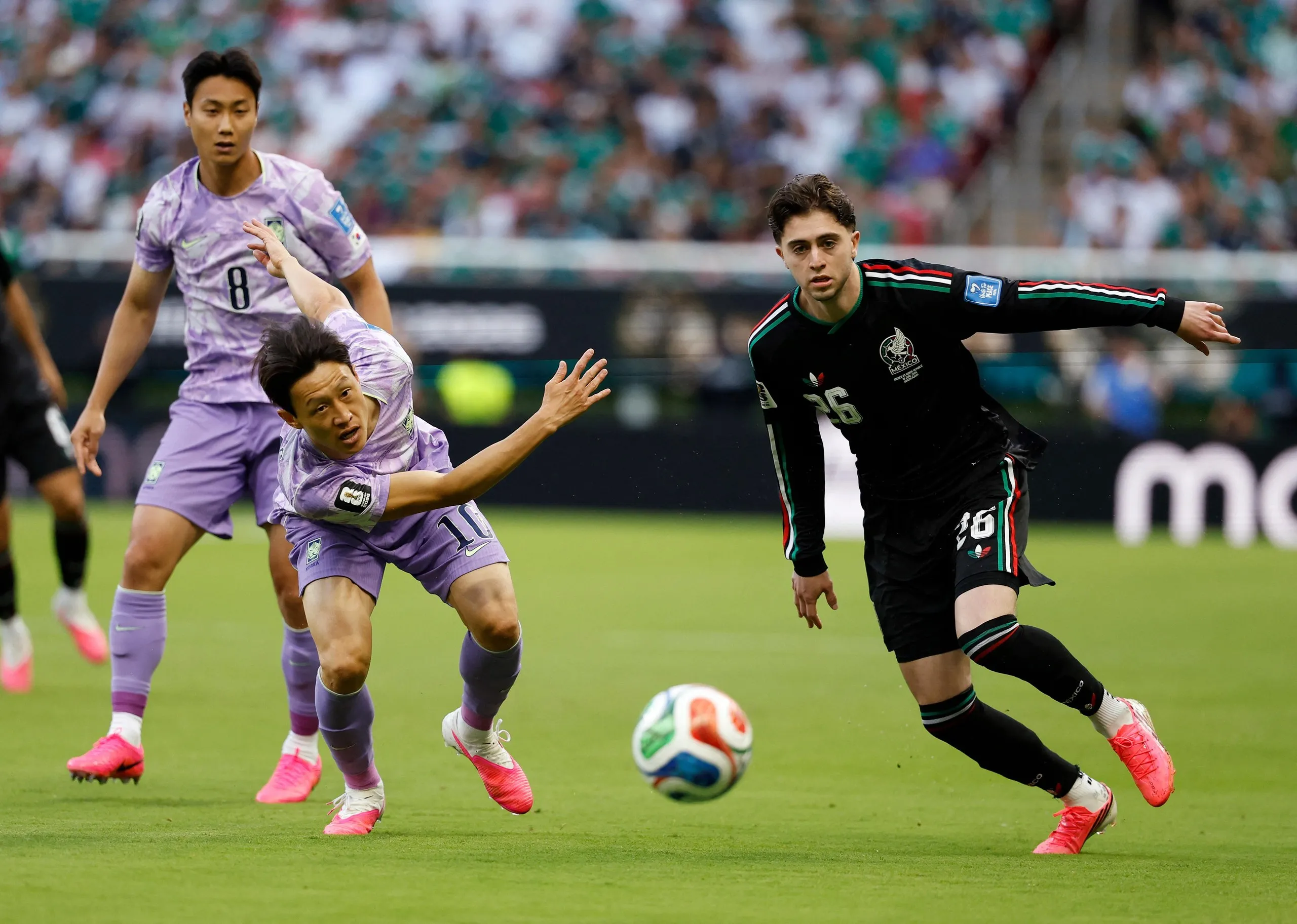 Brian Gutierrez escapes the attention of South Korea's midfielder Lee Jae-sung.