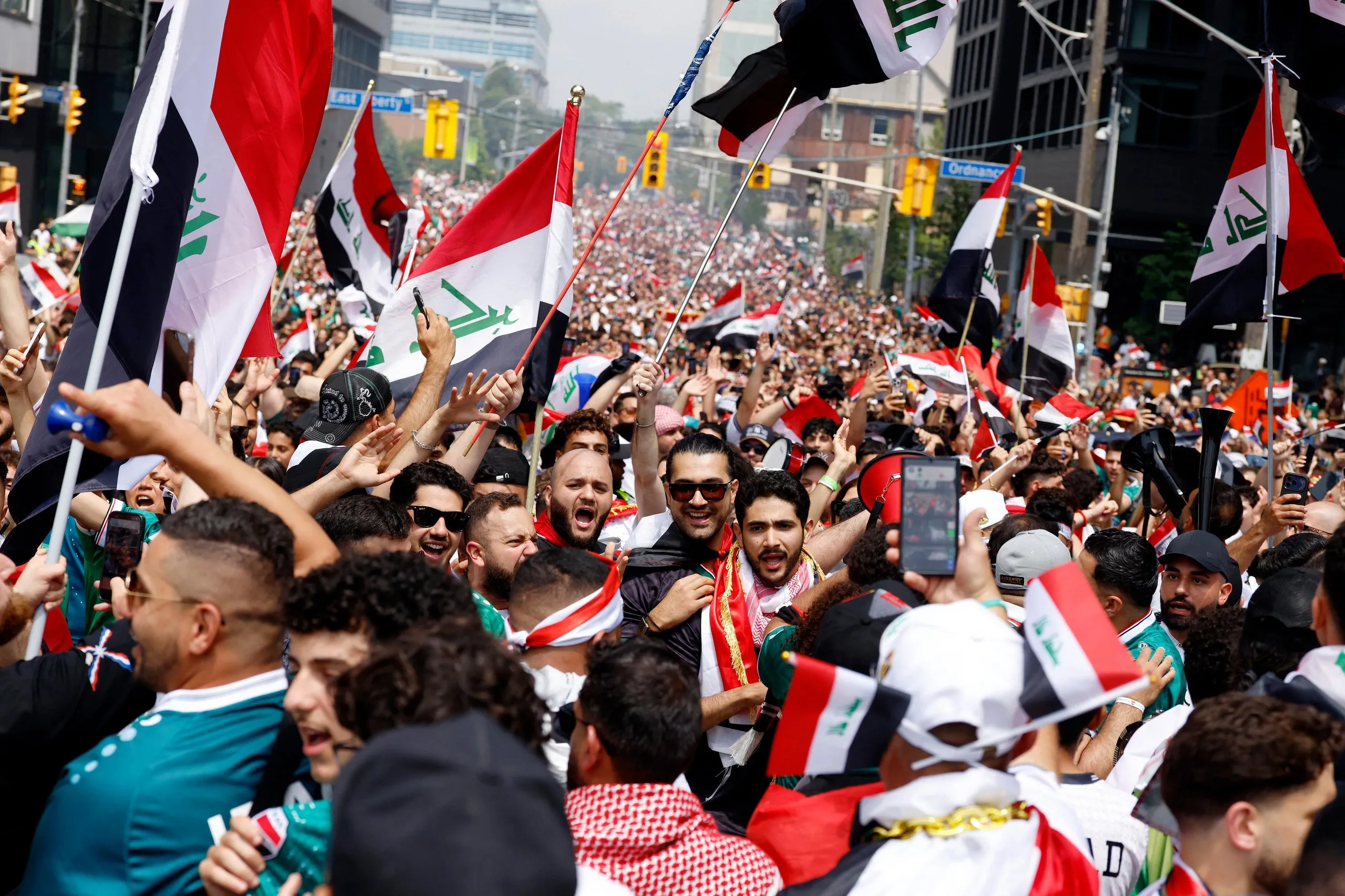 Iraq fans with their national flags march to the stadium in Toronto before their World Cup game against Senegal.
