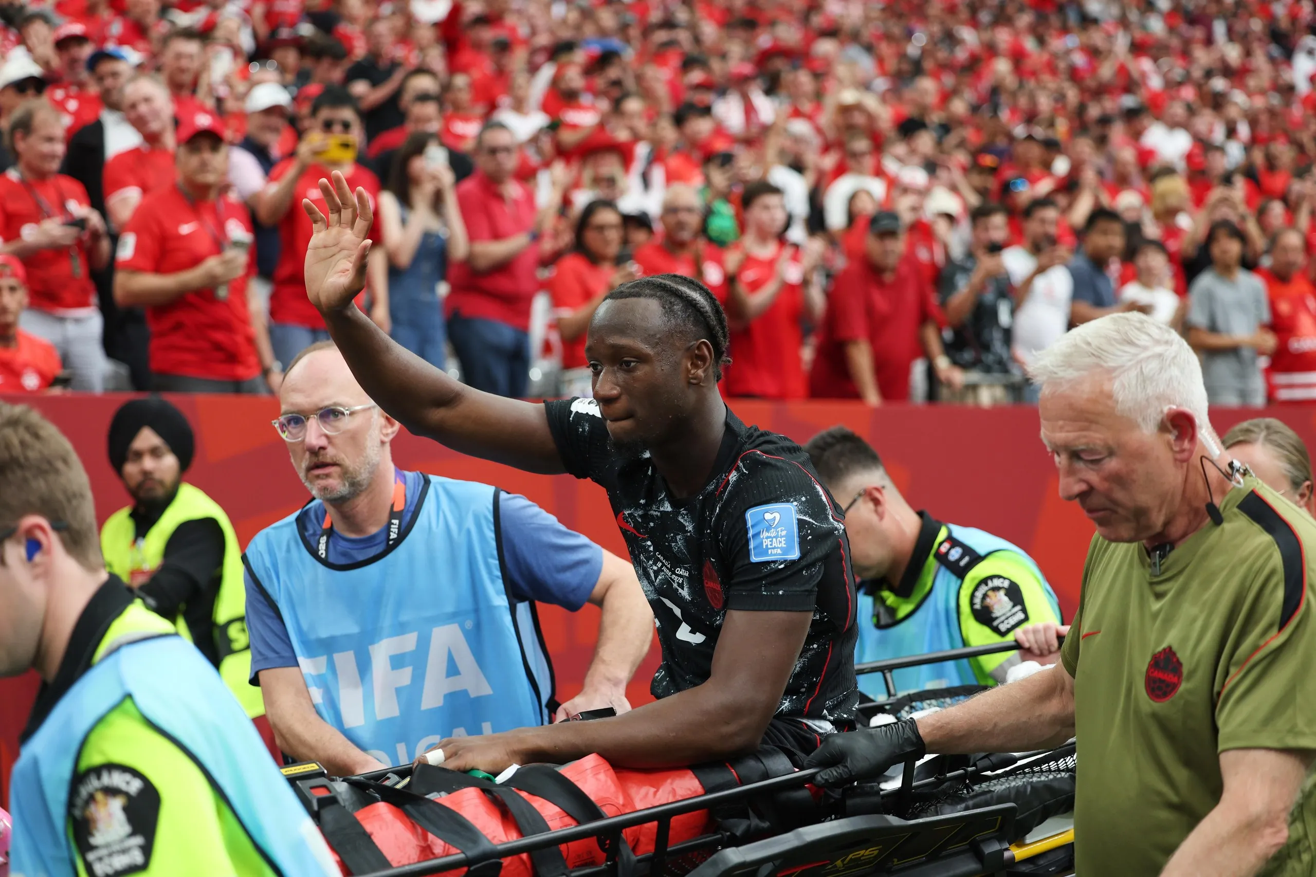 Ismaël Koné acknowledges the crowd as he’s stretchered off following his injury.