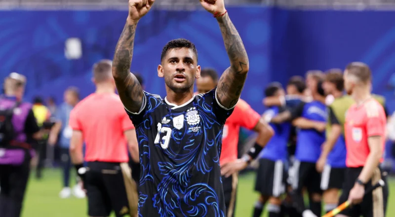 Cristian Romero lifts his arms aloft towards the crowd at the full time whistle.