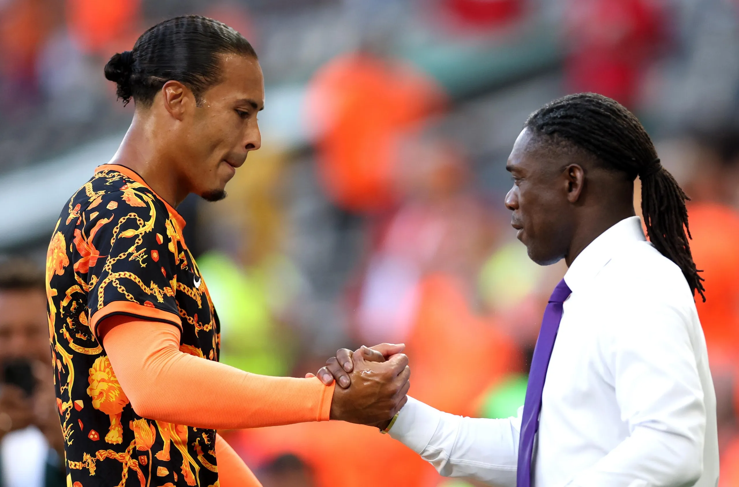 Clarence Seedorf greets compatriot Virgil van Dijk before the last 32 match between Netherlands and Morocco.